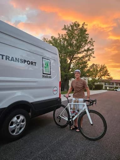 Customer with their bike beside the 3KtoGO van at sunset